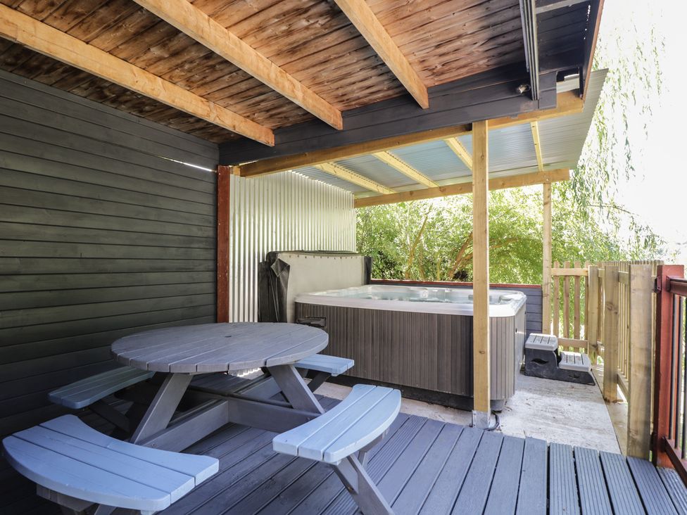 An outdoor area with a hot tub and a picnic table at West Down Country House in South Molton