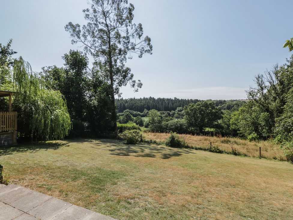 A garden with grass and trees at West Down Country House in South Molton
