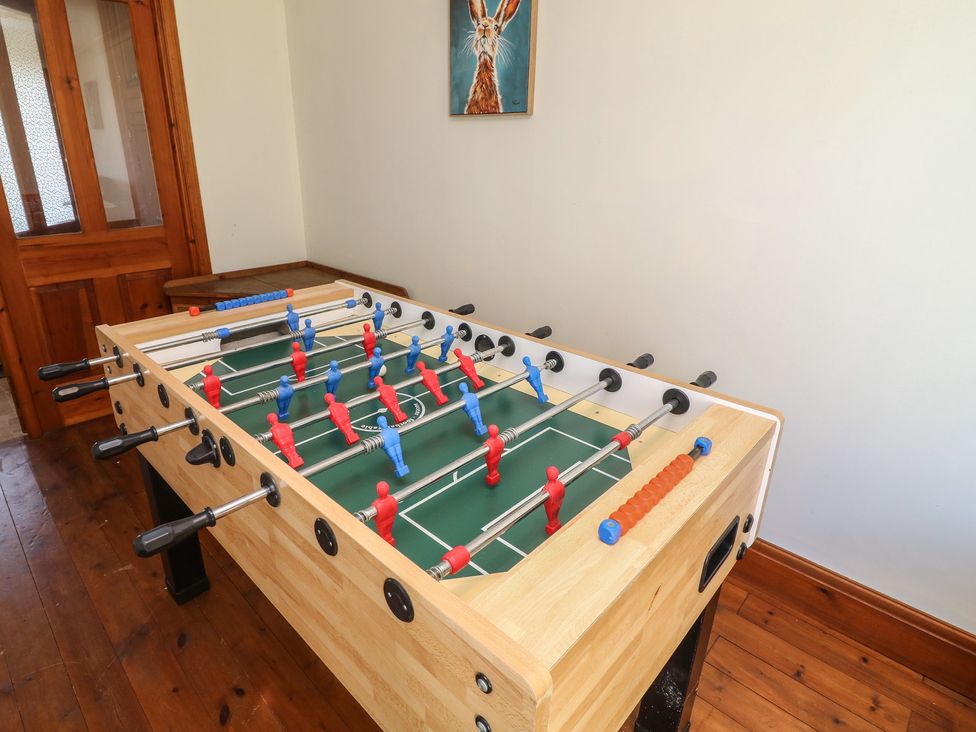 A foosball table with red and blue players in a recreation room at Highfields 