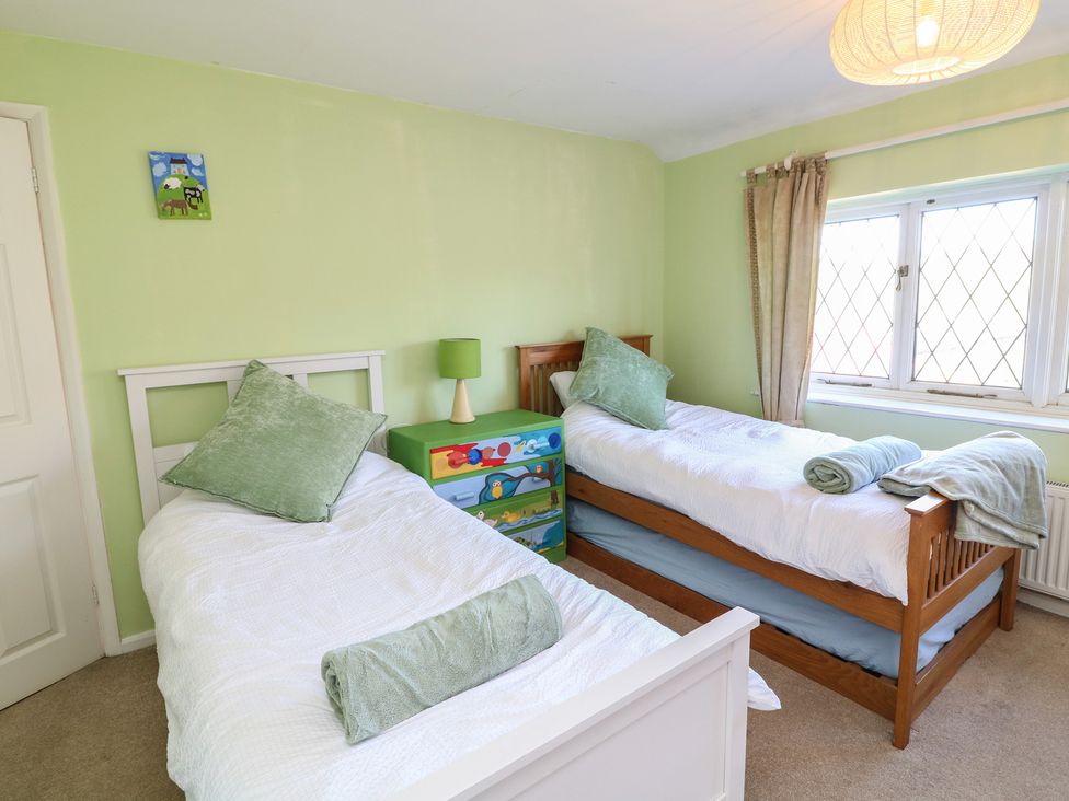 A bedroom with two beds and a green dressing table at Highfields