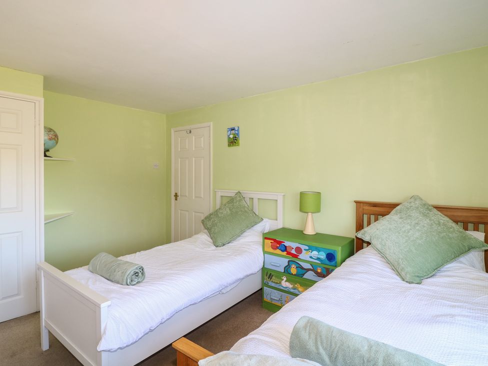 A bedroom with twin beds and a drawer unit at Highfields