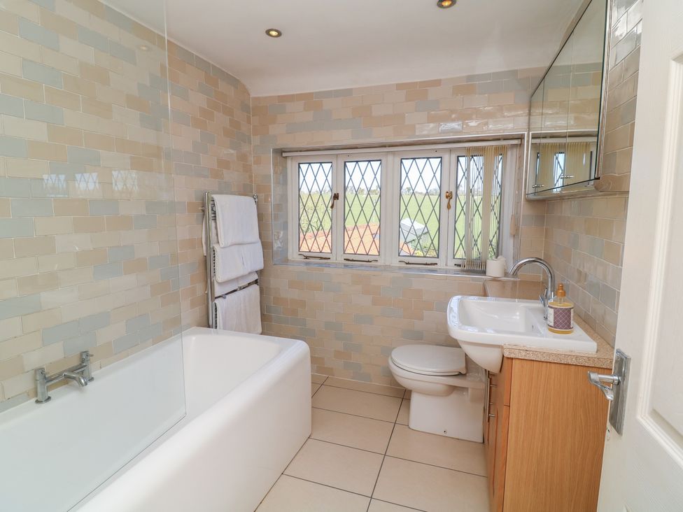 A bathroom with a bathtub, toilet, and sink at Highfields