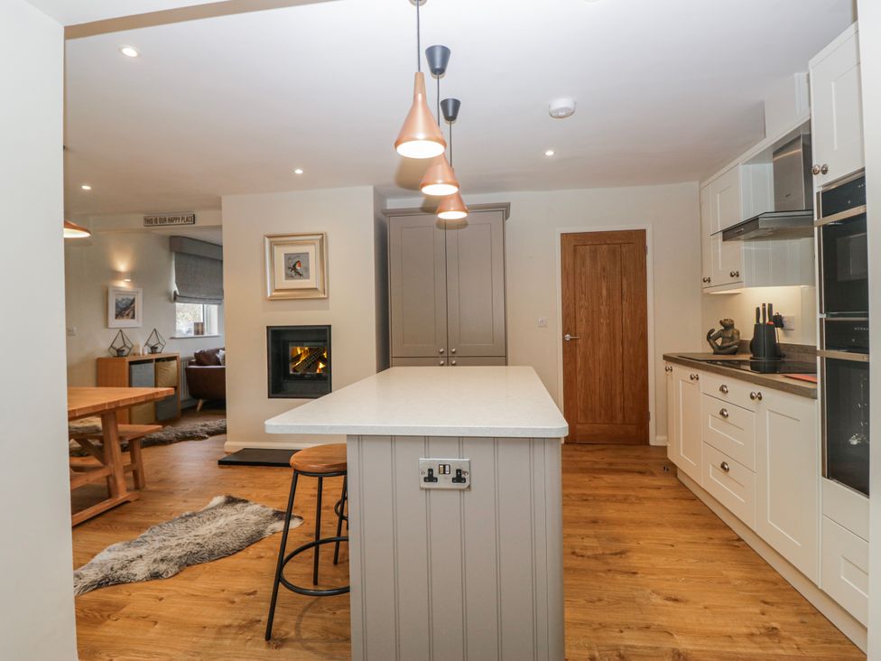 A kitchen with a kitchen island and bar stools at Ambwray in Ambleside