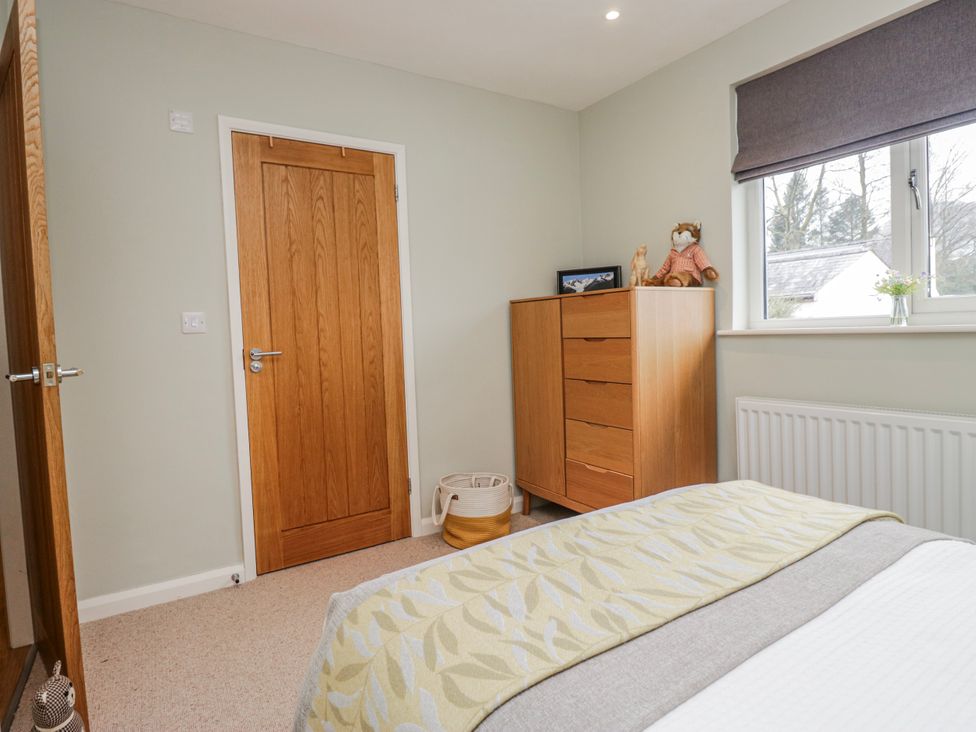 A bedroom with a wardrobe and a window at Ambwray in Ambleside