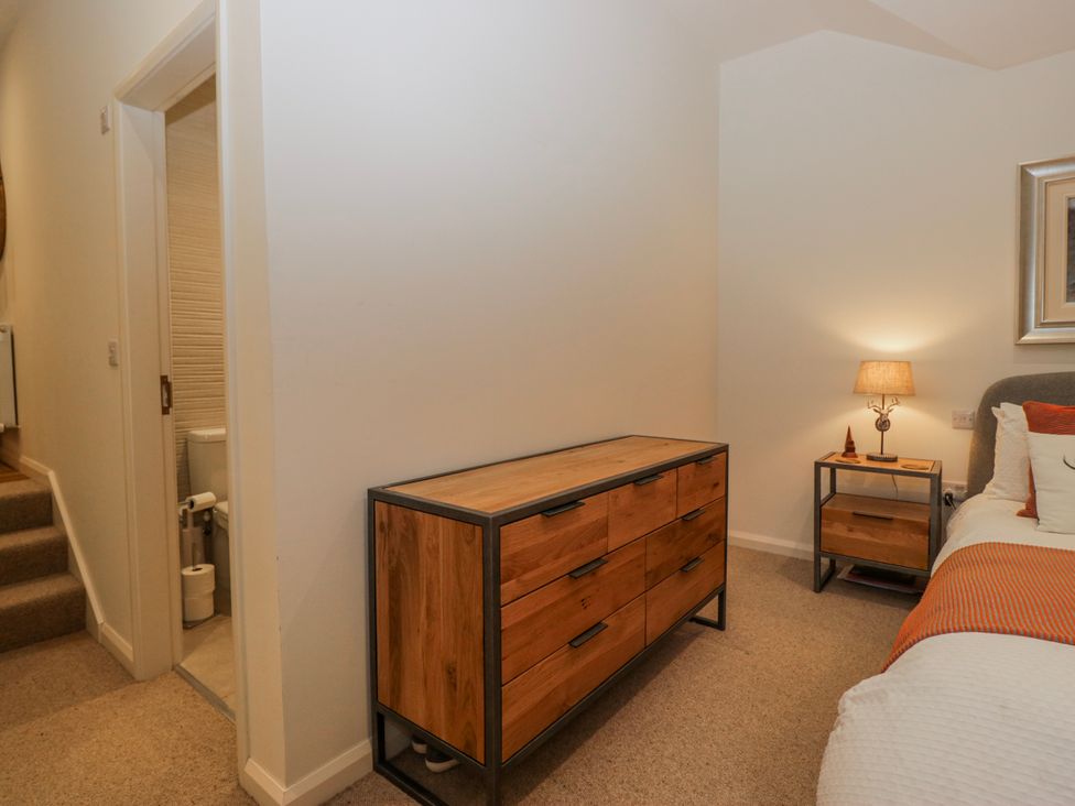 A bedroom with a dresser and side table at Ambwray in Ambleside