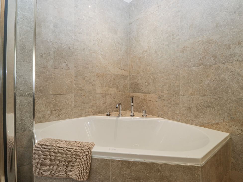 A bathtub with a towel in a bathroom at Ambwray in Ambleside