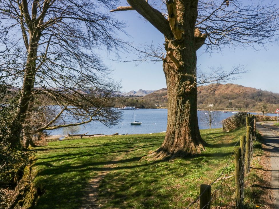 A view of a lake with a boat and tree at Ambwray in Ambleside