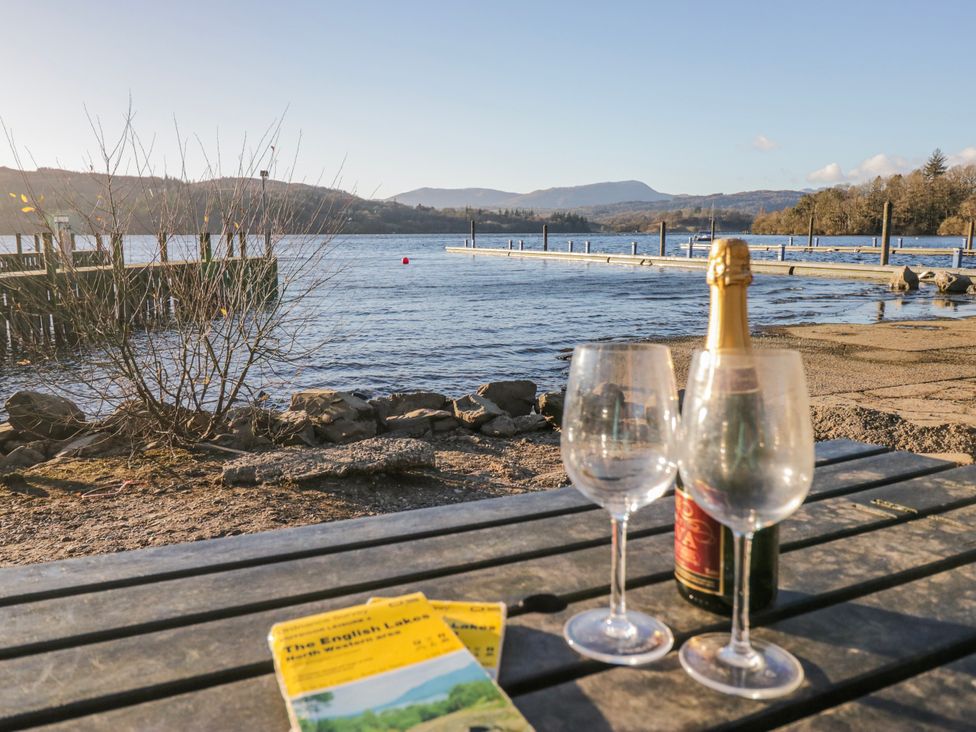 A table with glasses and champagne near the lake at Ambwray in Ambleside