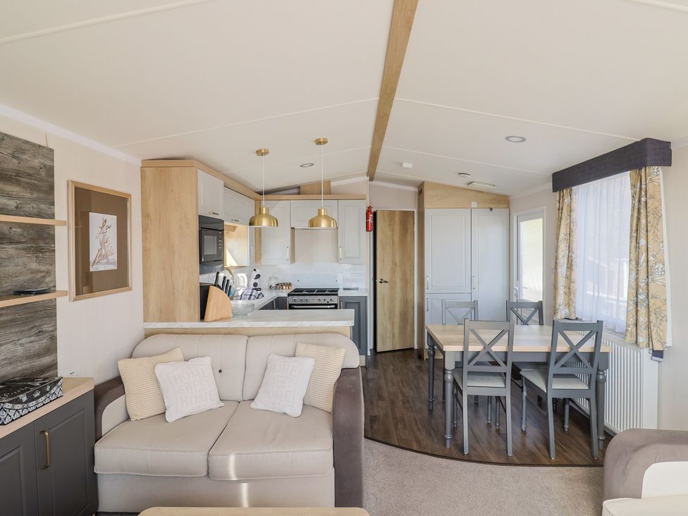 A living room with a sofa and dining area at Bordeaux Ladram Bay Otterton