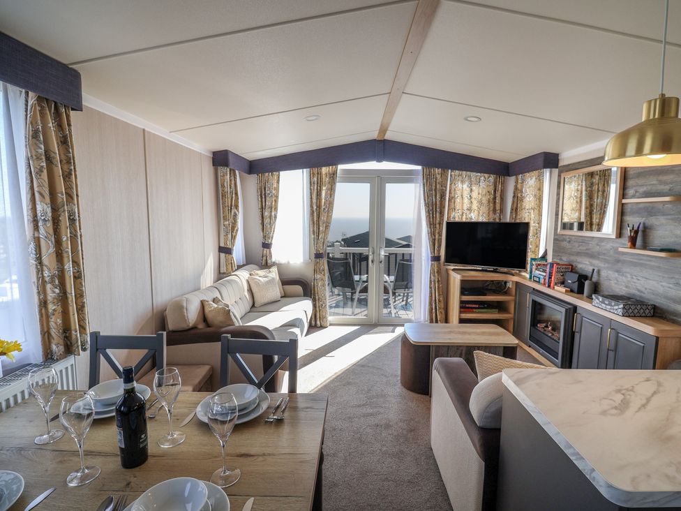 A living room with a sofa and dining table at Bordeaux in Ladram Bay Otterton