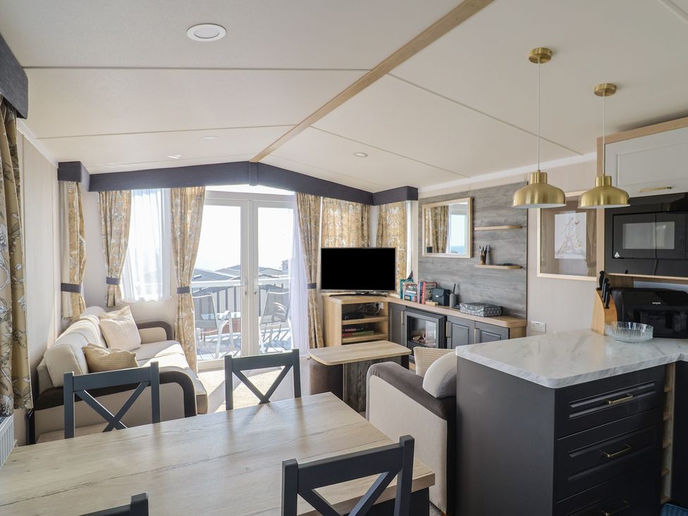 A living room with a sofa and dining table at Bordeaux in Ladram Bay Otterton