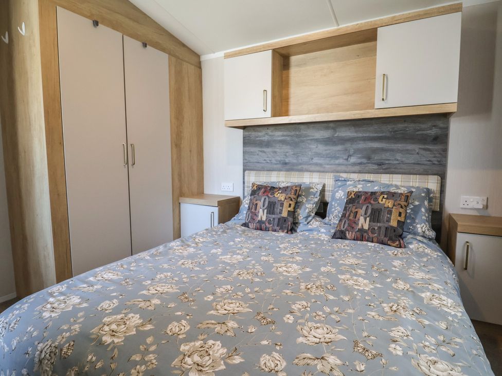 A bedroom with a bed and wardrobe at Bordeaux in Ladram Bay Otterton