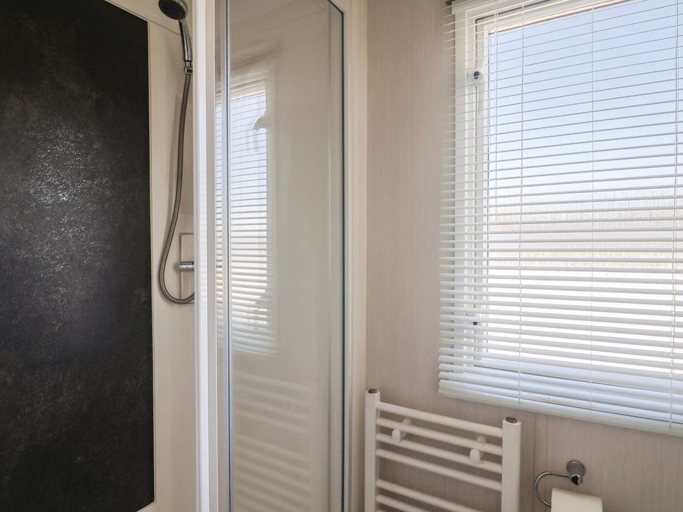 A bathroom with a shower and towel rack at Bordeaux Ladram Bay Otterton