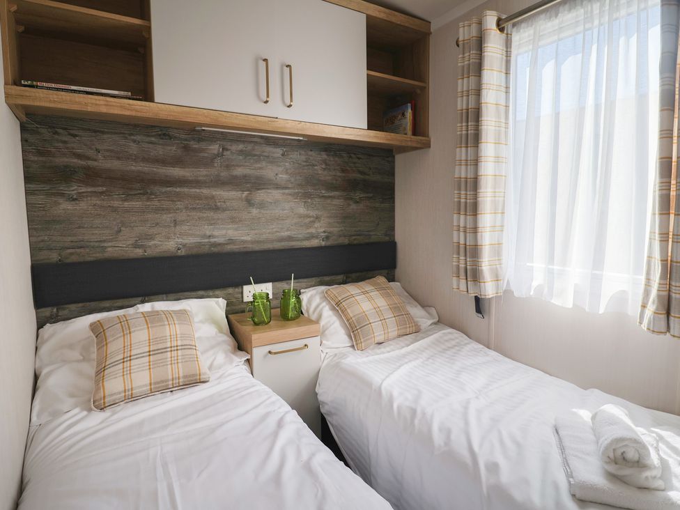 A bedroom with twin beds and a nightstand at Bordeaux in Ladram Bay Otterton