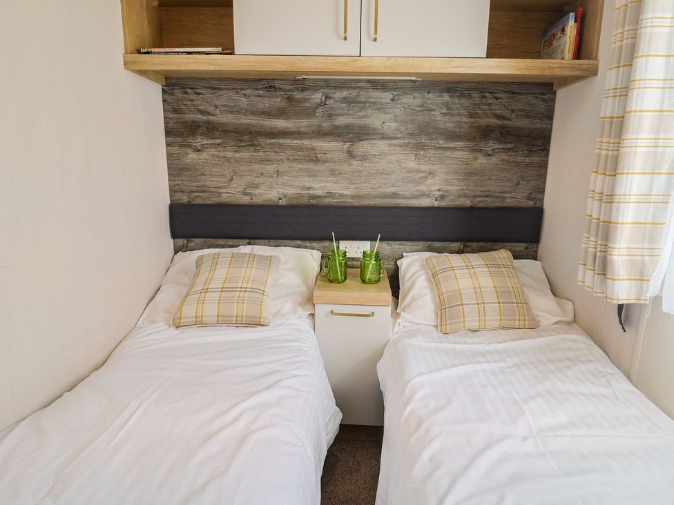 A bedroom with two beds and a bedside table at Bordeaux Ladram Bay Otterton