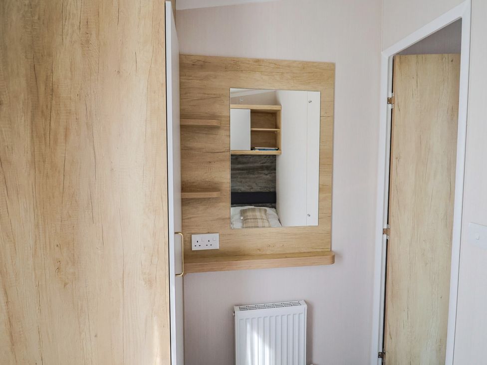 A bedroom with a mirror and shelves at Bordeaux Ladram Bay Otterton