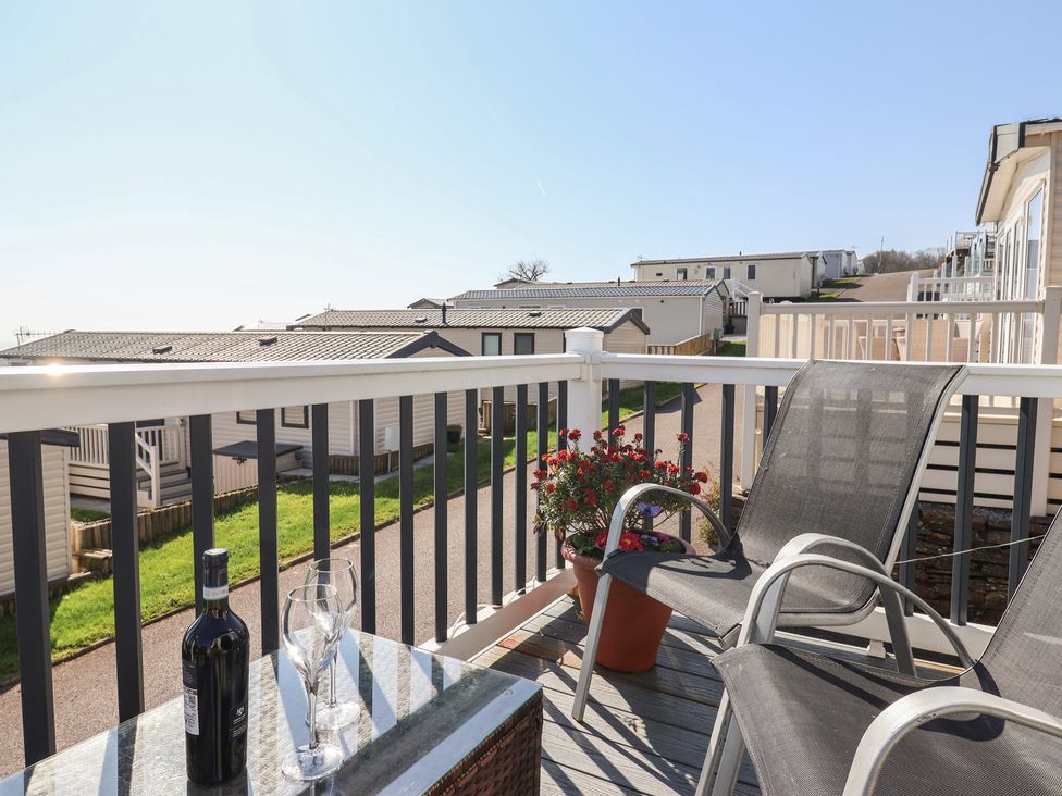 An outdoor area with a table, chairs and drinks at Bordeaux, Ladram Bay Otterton