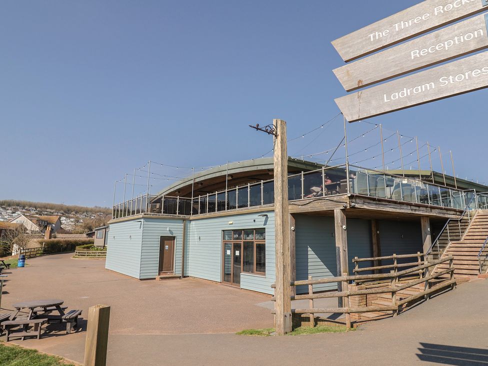 A building with a terrace and seating area at The Three Rocks in Ladram Bay Otterton