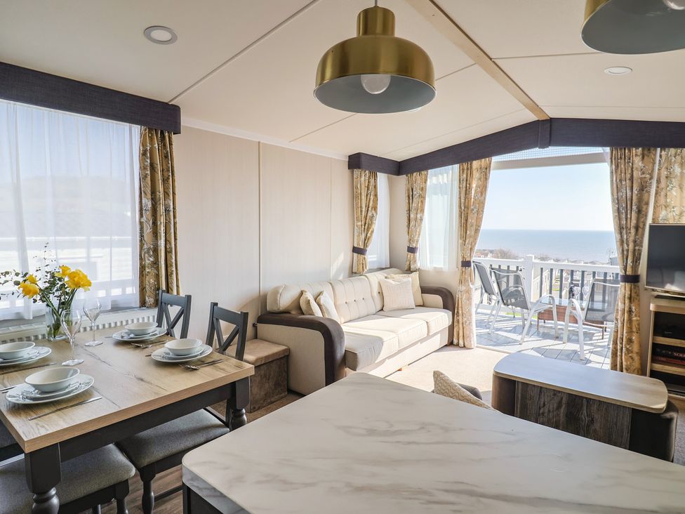 A living room with a sofa and dining table at Bordeaux in Ladram Bay Otterton