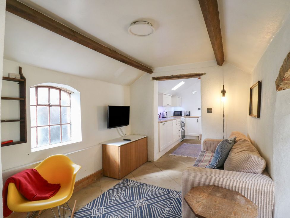 A living room with a sofa and television at Ravensthorpe Rural Retreat in Northampton