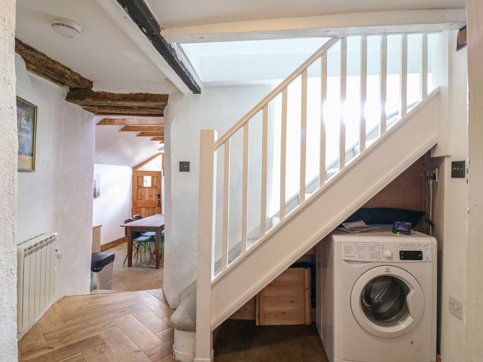 A hallway with a washing machine and staircase at Ravensthorpe Rural Retreat Northampton