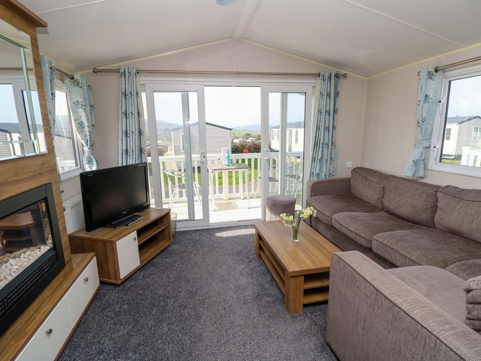 A living room with a sofa and television at 63 Crosswinds in Bembridge