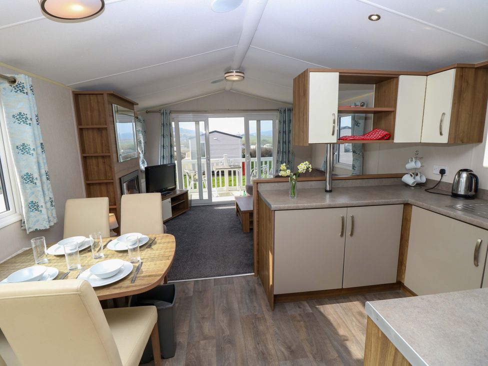 A kitchen with a dining table and chairs at 63 Crosswinds in Bembridge