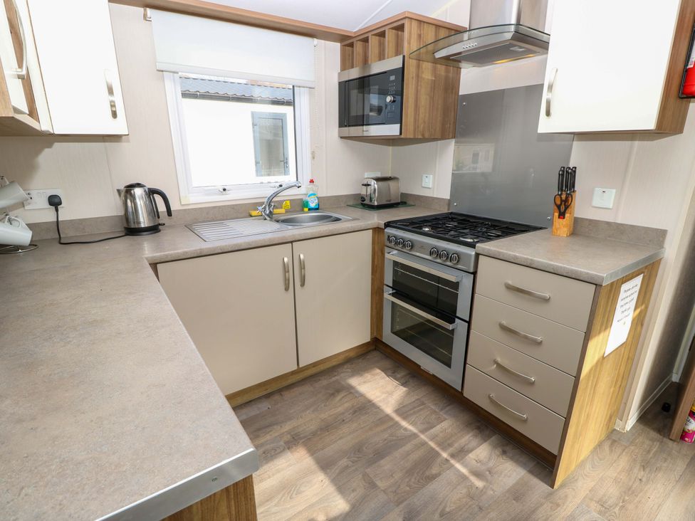 A kitchen with an oven and sink at 63 Crosswinds in Bembridge