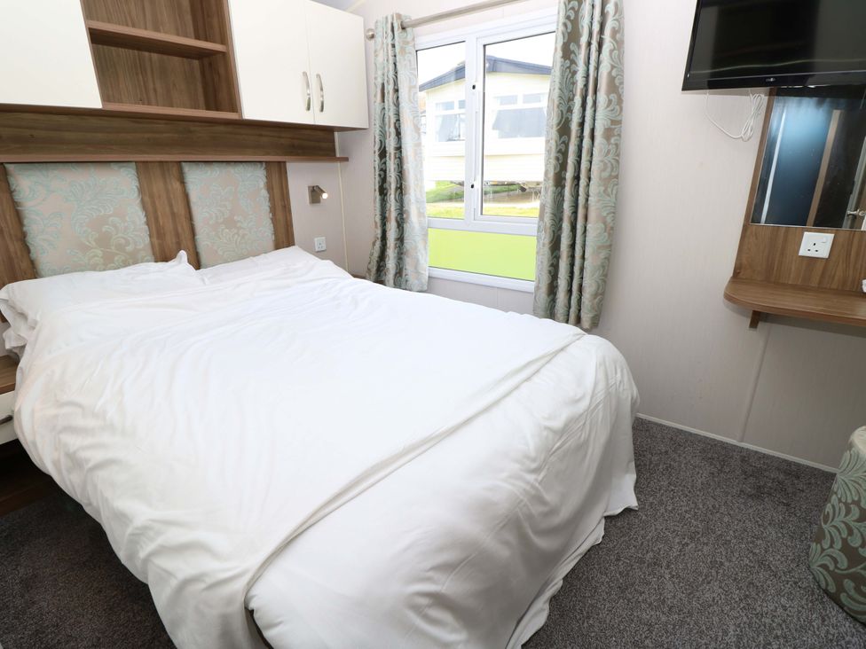 A bedroom with a bed and television at 63 Crosswinds in Bembridge