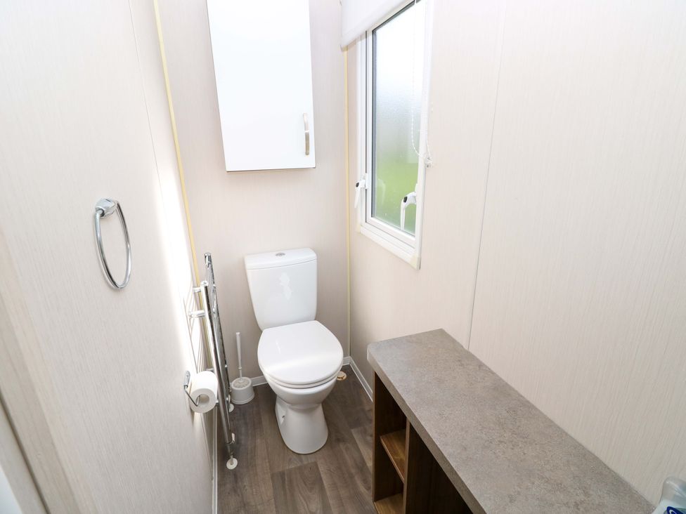 A bathroom with a toilet and sink at 63 Crosswinds in Hillway near Bembridge