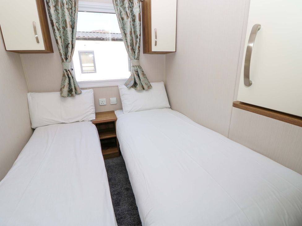 A bedroom with two single beds at 63 Crosswinds near Bembridge