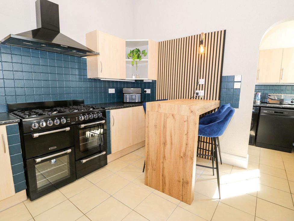 A kitchen with cabinets and a bar counter at The Causeway in Llandudno