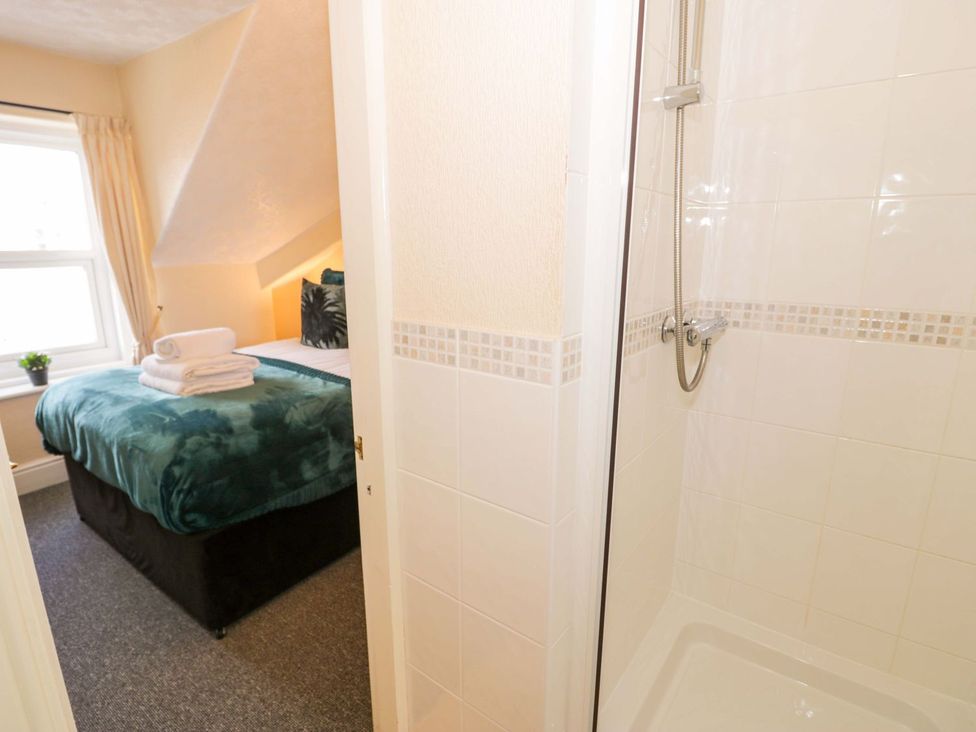 A bedroom with a bed and shower at The Causeway in Llandudno