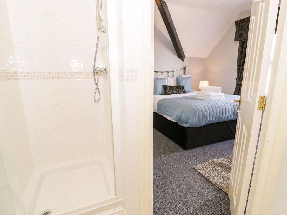 A bathroom with a shower and a view of a bedroom at The Causeway in Llandudno