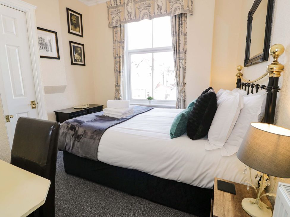 A bedroom with a bed and a window at The Causeway in Llandudno