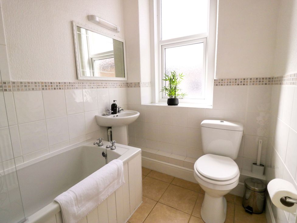 A bathroom with a bathtub, toilet, and sink at The Causeway in Llandudno
