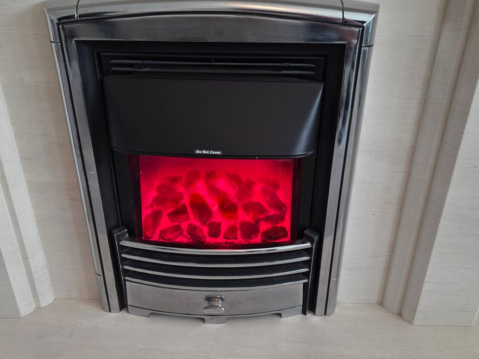 An electric fireplace with flame effect at Spacious 4-Bedroom Cotswold Home in Lechlade