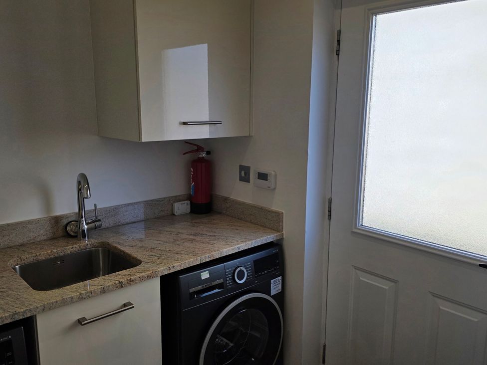 A laundry room with a sink and washing machine at Spacious 4-Bedroom Cotswold Home in Lechlade
