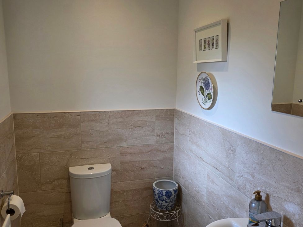 A bathroom with a toilet, hand wash basin and wall art at Spacious 4-Bedroom Cotswold Home in Lechlade