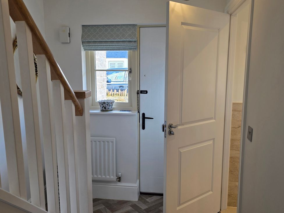 A hallway with a staircase and a door at Spacious 4-Bedroom Cotswold Home in Lechlade