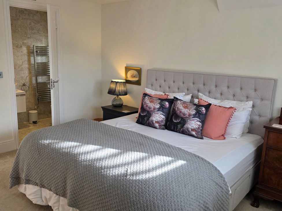 A bedroom with a bed and bedside table at Spacious 4-Bedroom Cotswold Home in Lechlade