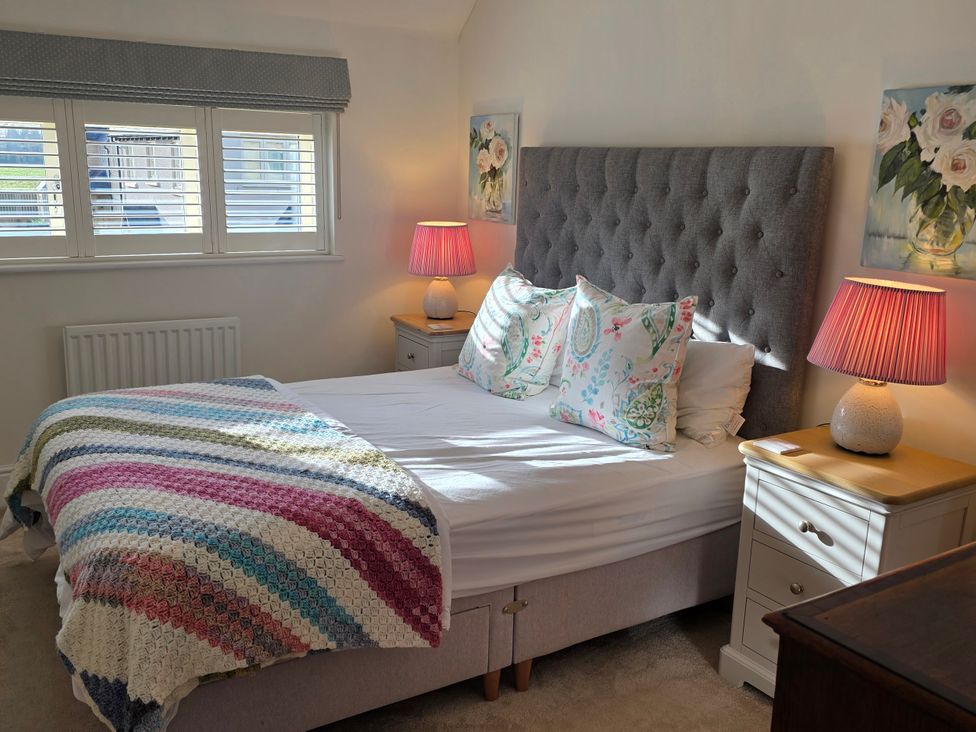 A bedroom with a bed and nightstands at Spacious 4-Bedroom Cotswold Home in Lechlade