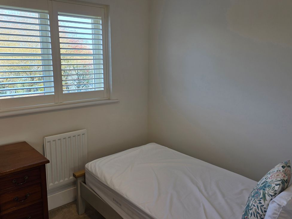 A bedroom with a bed and dresser at Spacious 4-Bedroom Cotswold Home in Lechlade