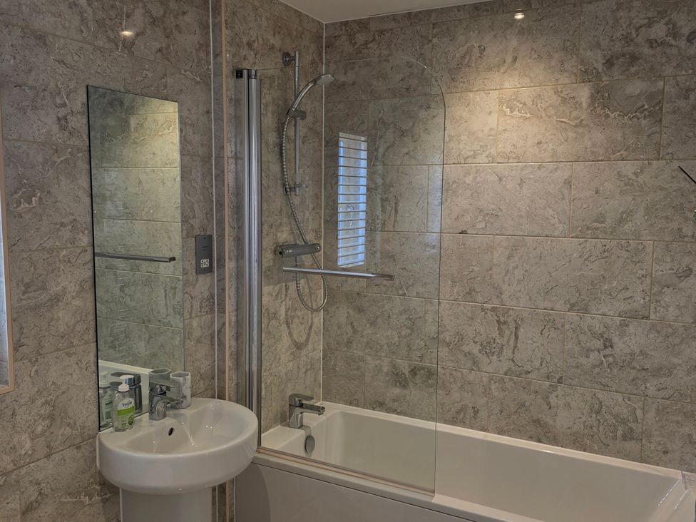 A bathroom with a bathtub, sink and shower at Spacious 4-Bedroom Cotswold Home in Lechlade