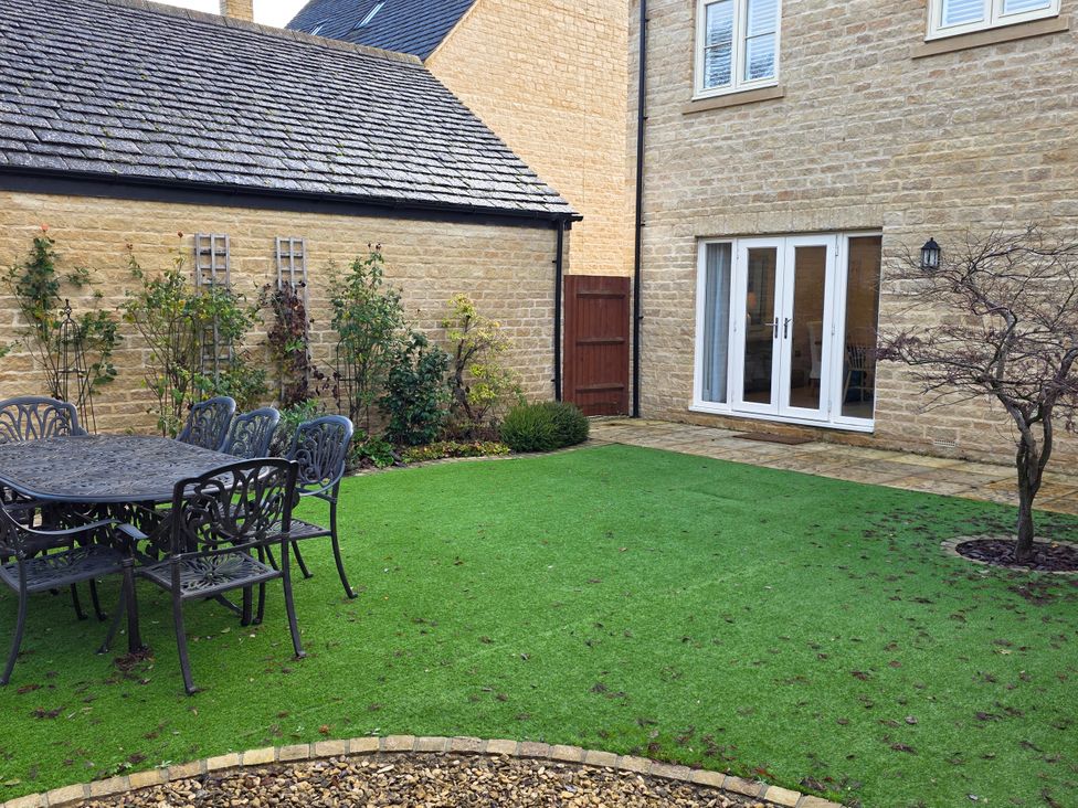 A garden with a table and chairs at Spacious 4-Bedroom Cotswold Home in Lechlade