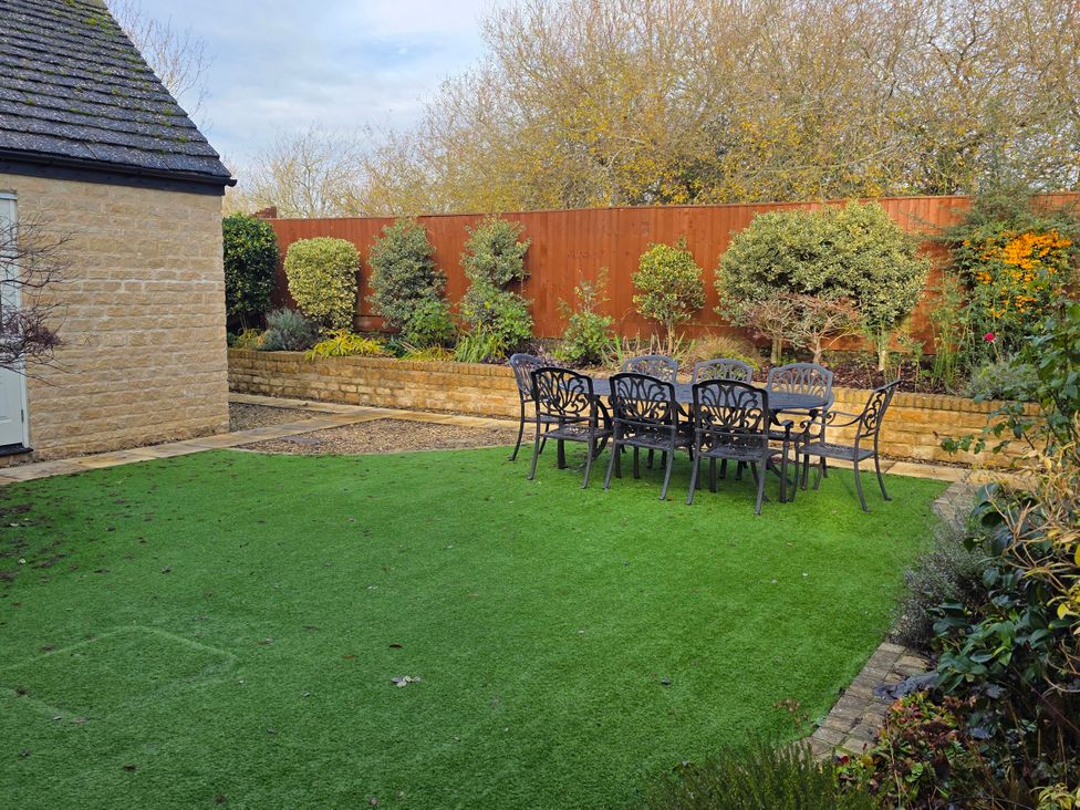 A garden with a table and chairs at Spacious 4-Bedroom Cotswold Home in Lechlade