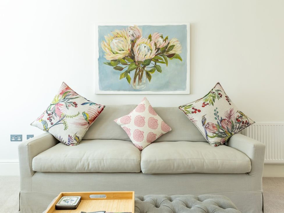 A couch with decorative pillows and artwork at Old Railway Close Lechlade-On-Thames