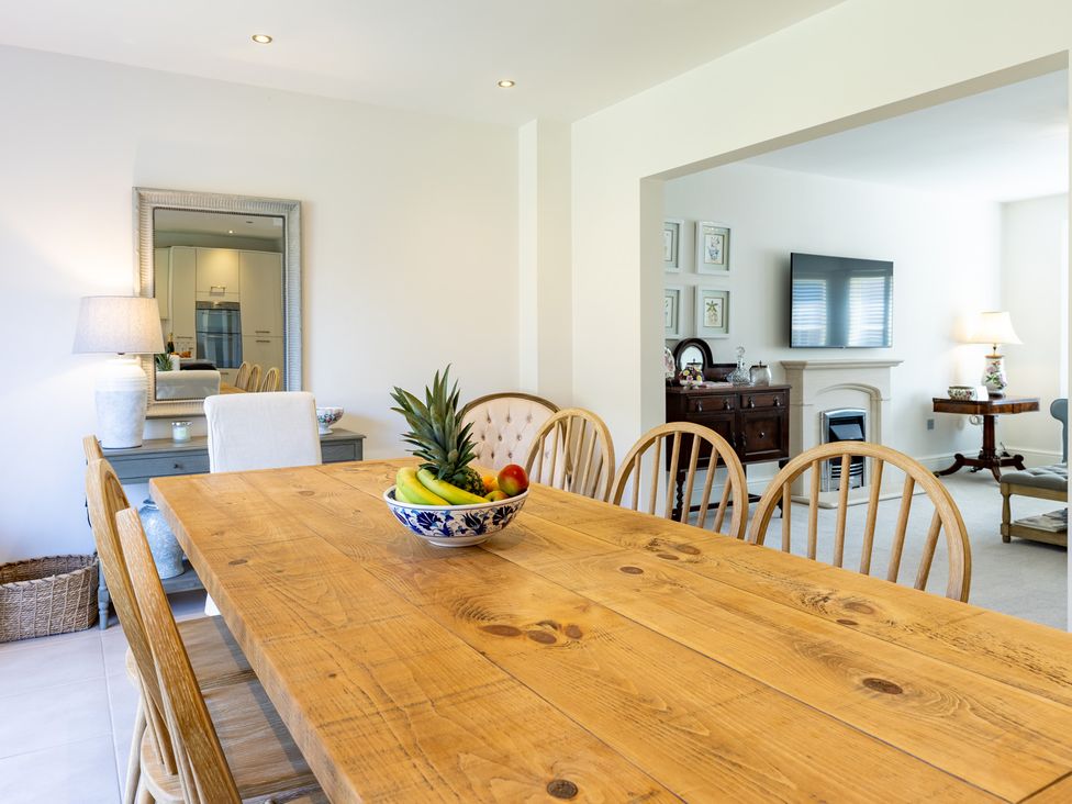 A dining room with a wooden table and fruit bowl at Old Railway Close, Lechlade-On-Thames