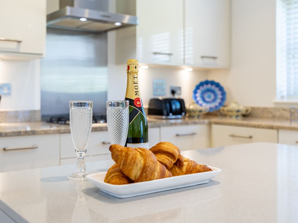 A kitchen with champagne and croissants on a countertop at Old Railway Close Lechlade-On-Thames