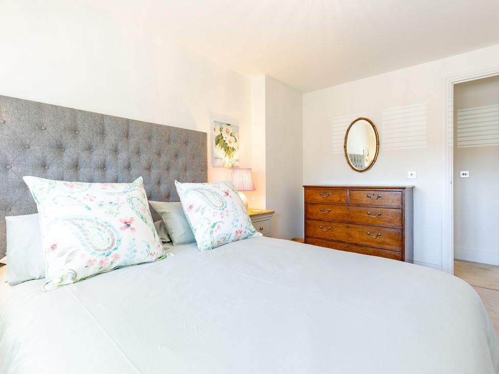 A bedroom with a bed and wooden chest of drawers at Old Railway Close in Lechlade-On-Thames